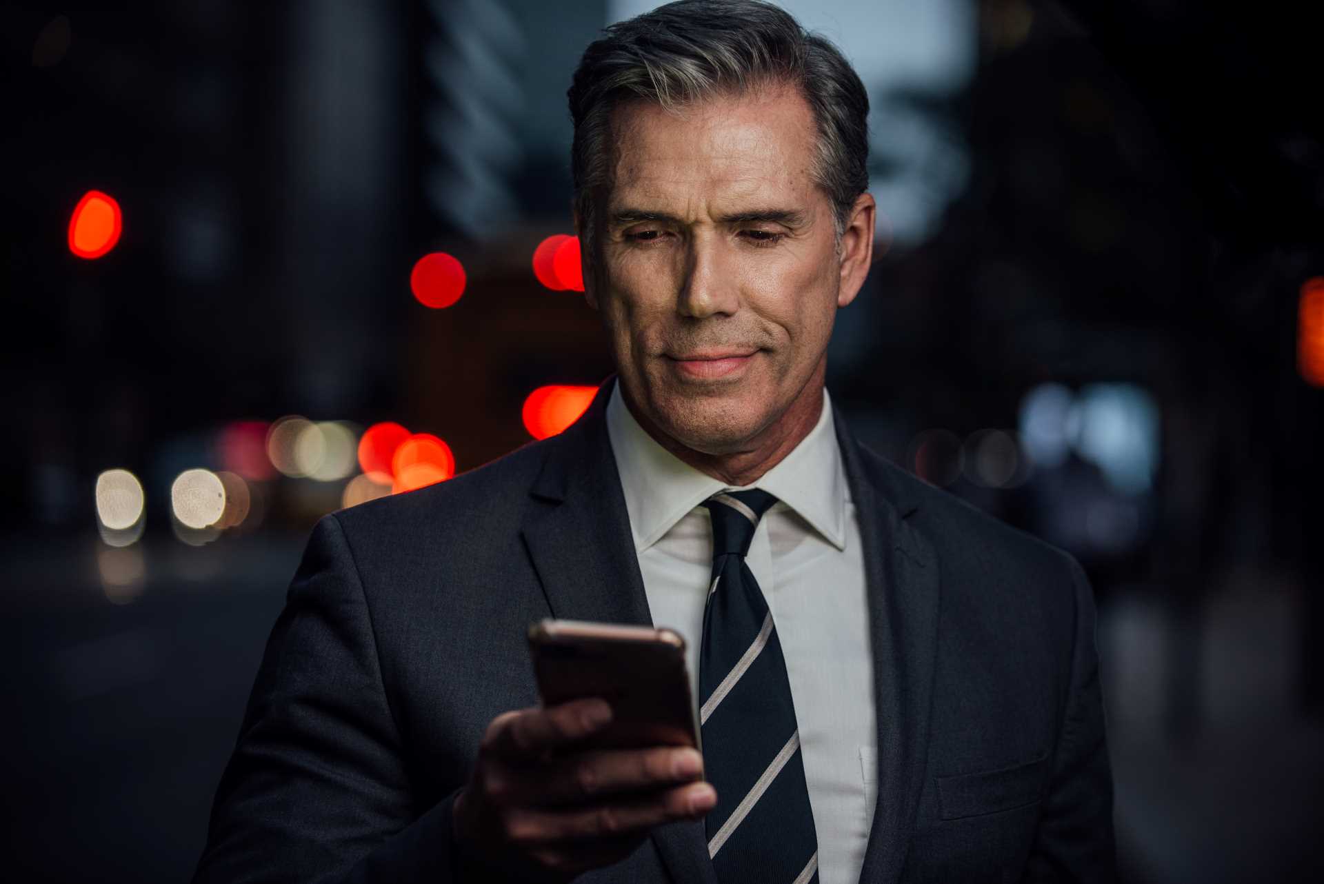 homem de negócios olhando no celular para consultar uma lista restritiva