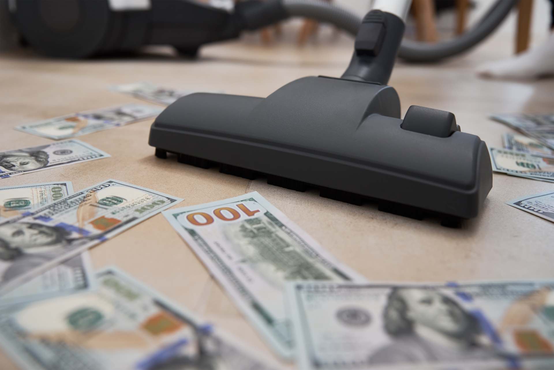 lavagem de dinheiro representada por um aspirador de pó aspirando notas de dolar